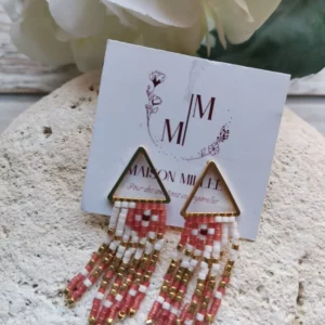 Clous d'oreilles dorés 24k en forme de triangles avec 7 fils de perles qui pendent.Longueur 38mm. Le tout posé sur une pierre blanche.