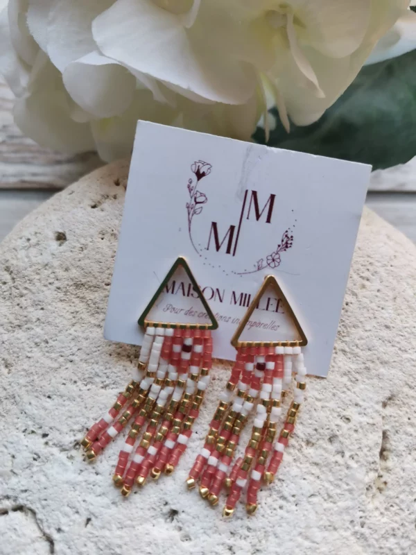Clous d'oreilles dorés 24k en forme de triangles avec 7 fils de perles qui pendent.Longueur 38mm. Le tout posé sur une pierre blanche.