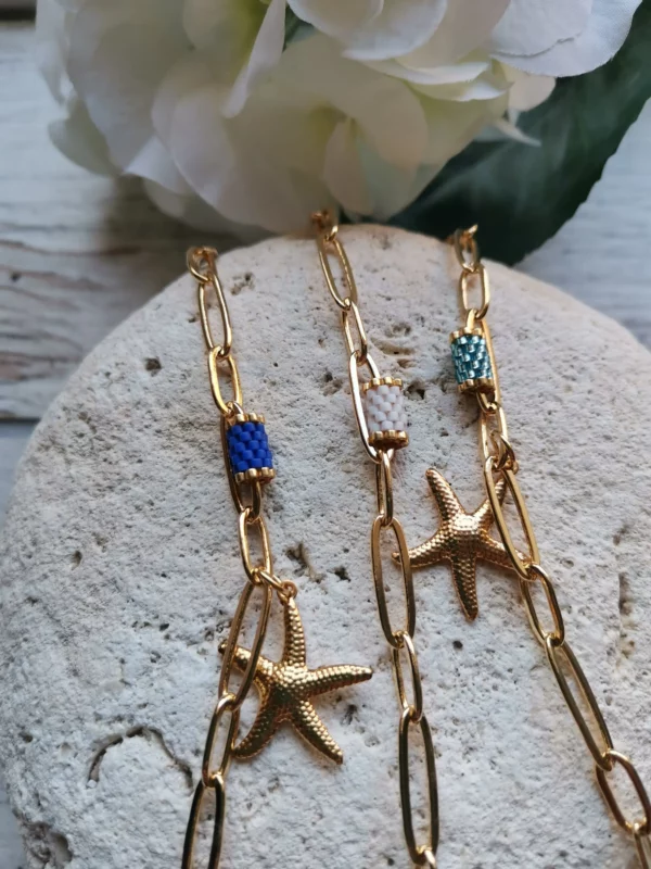 Trois bracelets en perles Miyuki bleu blanc ciel acier inoxydable les uns à côté des autres sur une pierre blanche, Chaine mailles rectangles Collection STAR