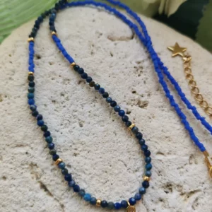 Collier de perles facettées de Lapis lazuli de 3mm, associées à des perles Miyuki bleu cyan. Un petit pendentif cactus rehausse le collier qui est posé sur une pierre blanche.