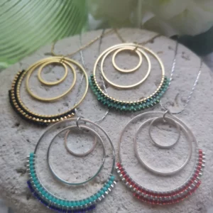 Ensemble de Colliers 3 anneaux dont le grand est tissé de perles Miyuki. Dorés ou argentés, ils sont posés sur une pierre blanche.