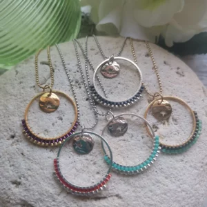 Ensemble de colliers avec un anneau tissé à moité de perles Miyuki et orné d'une breloque ronde ajouré d'une étoile. Le tout posé sur une pierre blanche.