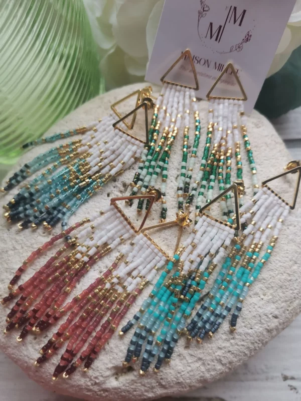 Ensemble de boucles triangles dorées avec fils de perles Miyuki en dégradé de rose, de bleu et de vert. Toutes posées sur une pierre blanche.
